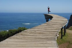 A woman doing yoga on the dock with the beautiful ocean view