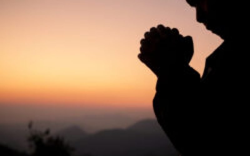 Silhouette of girl praying over beautiful sky background. Christian Religion concept background. fighting and victory for god