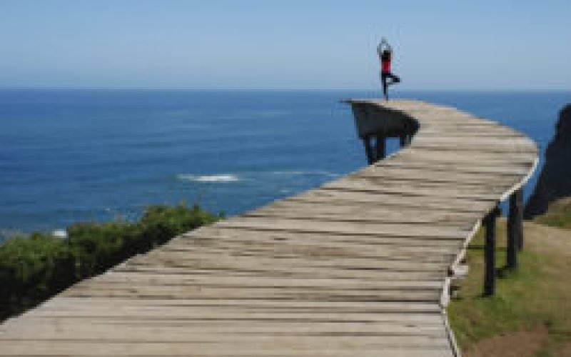 A woman doing yoga on the dock with the beautiful ocean view
